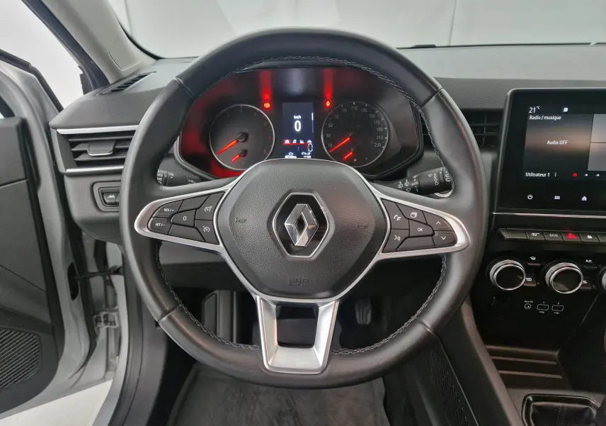 Vue intérieure centrée sur le volant de la Renault Clio V 1.0 TCE 90 Zen avec tableau de bord et écran tactile.