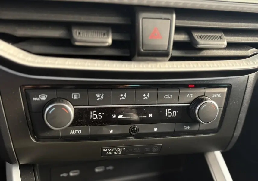 Gros plan sur la console centrale du SEAT Arona 2024 avec climatisation automatique et réglages digitaux.