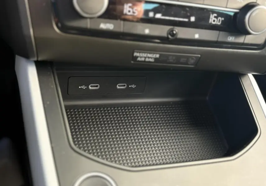 Gros plan sur la console centrale noire du SEAT Arona 2024, montrant deux ports USB-C et commandes climatisation.