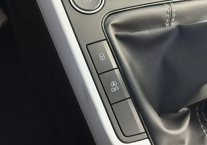 Gros plan sur la console centrale du SEAT Arona 2024 montrant le levier de vitesses manuel et les boutons de verrouillage et arrêt auto start-stop.