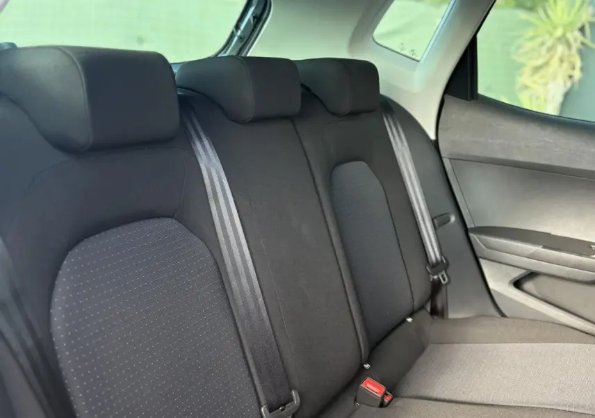 Vue latérale intérieure montrant la banquette arrière noire du SEAT Arona 2024 avec ceintures et appuie-têtes.