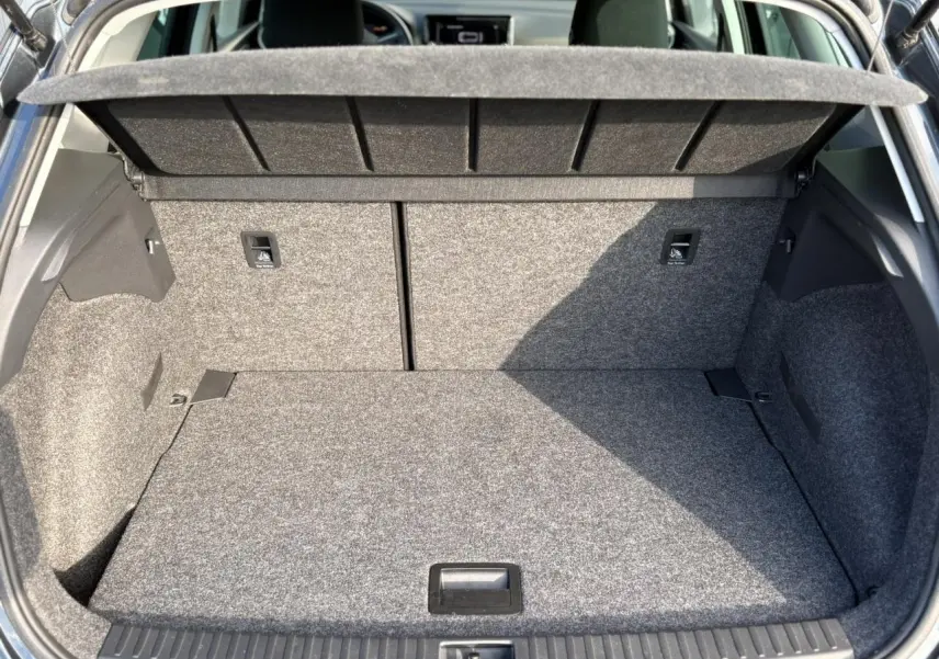 Coffre ouvert d'une SEAT Arona gris magnétique, montrant l'espace de chargement et les fixations ISOFIX arrière.