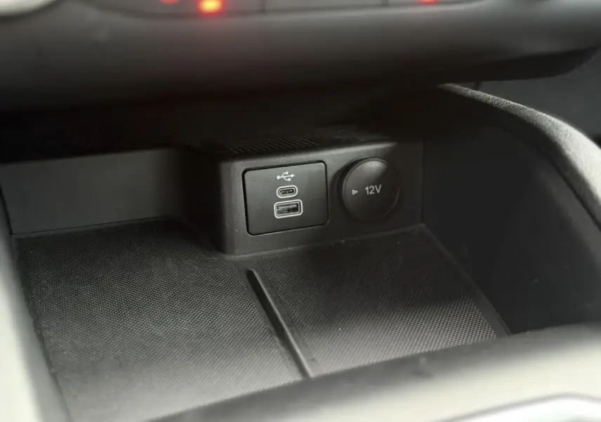 Gros plan sur les ports USB et prise 12V dans la console centrale du Ford Kuga noir Obsidien 2024.