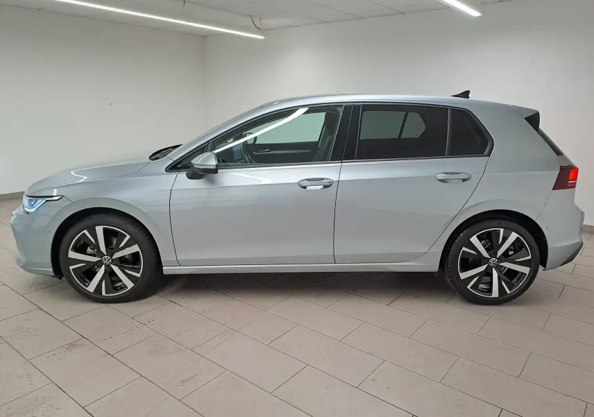 Vue de profil côté gauche d'une Volkswagen Golf 1.5 eTSI 116 BVM6 VW Edition argent Dolomite avec jantes alliage 18 pouces.