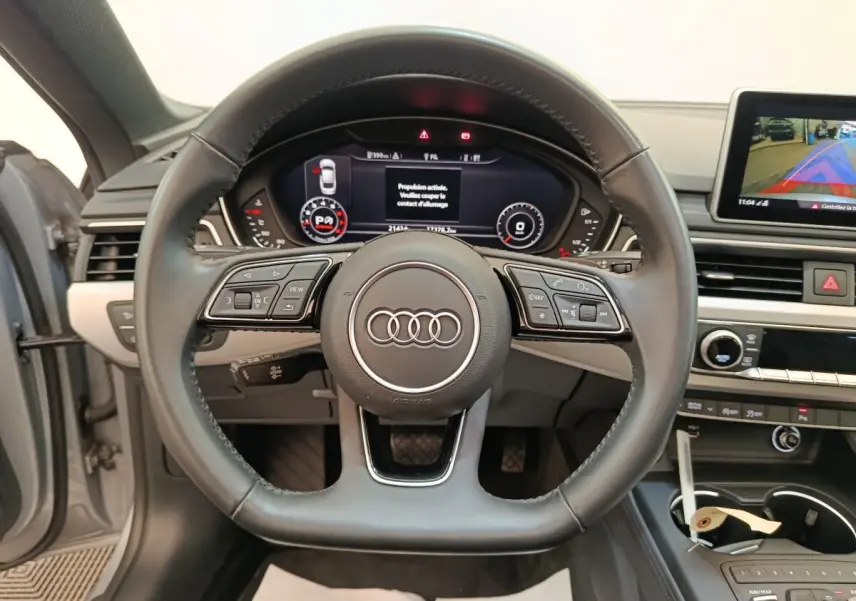 Vue centrée sur le volant cuir noir de l'Audi A5 40 TFSI 2019 avec tableau de bord digital et écran multimédia.