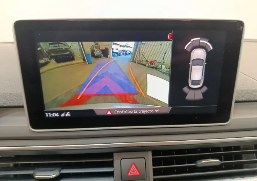 Affichage écran intérieur montrant la caméra de recul et l'aide au stationnement de l'Audi A5 gris clair 2019.