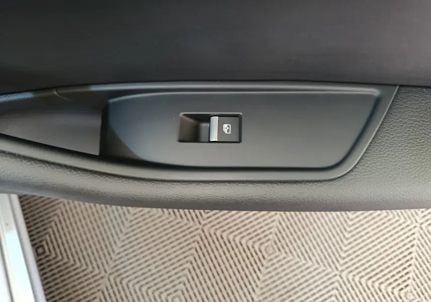 Bouton de commande de lève-vitre électrique sur la porte intérieure côté conducteur, plastique noir mat.