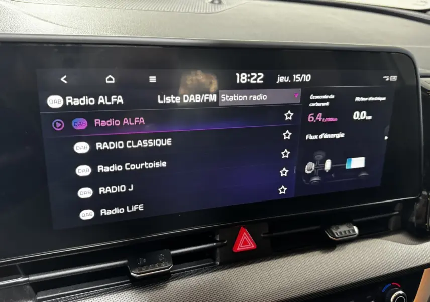 Écran tactile central du tableau de bord du Kia Sportage blanc 2024 affichant les stations radio DAB/FM.