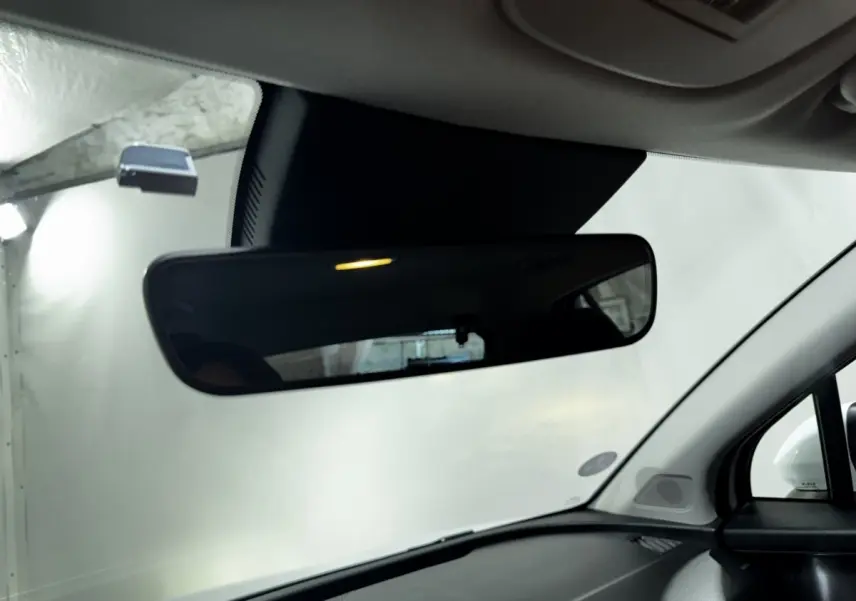 Vue intérieure du rétroviseur central du Kia Sportage blanc 2024, avec tableau de bord et pare-brise visibles.