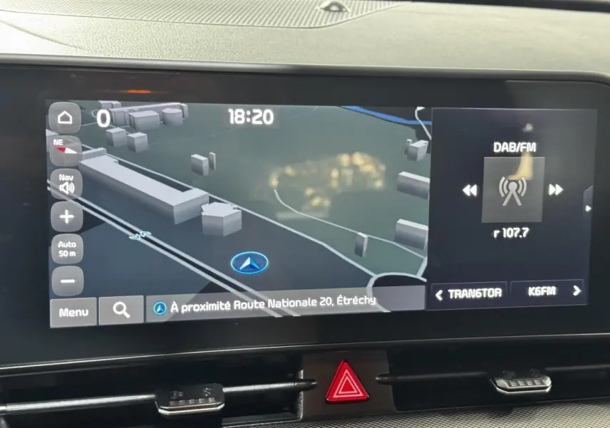 Écran tactile central du Kia Sportage blanc 2024 affichant la navigation et la radio DAB/FM.