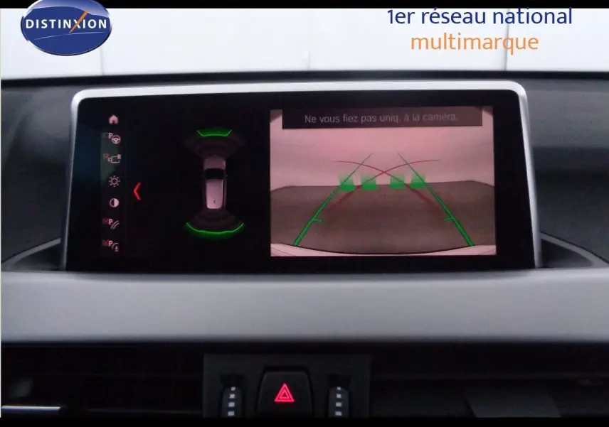 Écran central du BMW X1 2022 montrant la caméra de recul et les capteurs de stationnement actifs.
