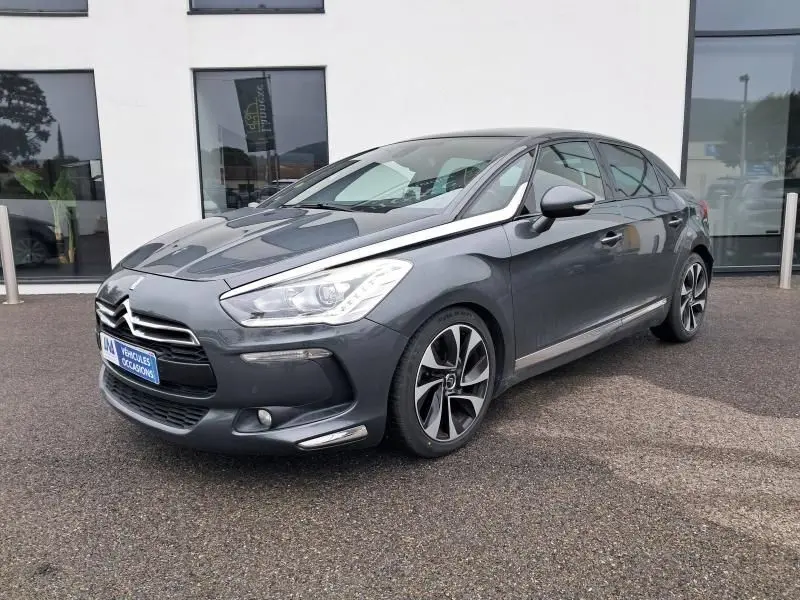 Citroën DS5 gris foncé métal vue 3/4 avant droit, avec jantes sport et signature lumineuse distinctive.