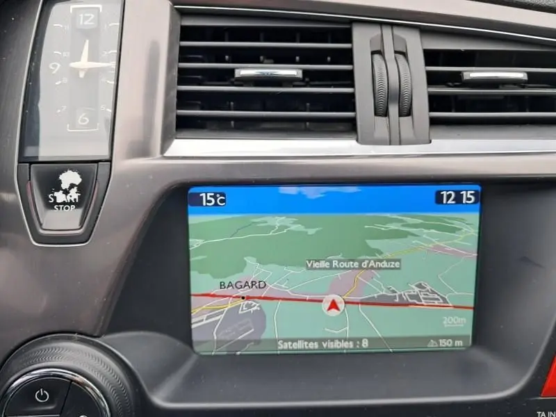 Vue rapprochée de la console centrale de la Citroën DS5 gris foncé, affichant la navigation GPS et la commande Start/Stop.