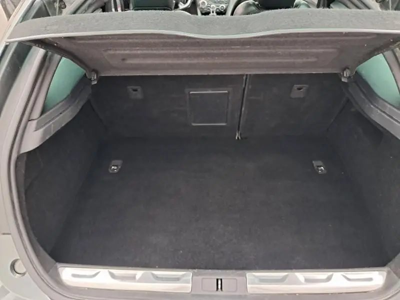Coffre ouvert vu de l'arrière d'une Citroën DS5 gris foncé métal, montrant un espace de chargement propre et spacieux.