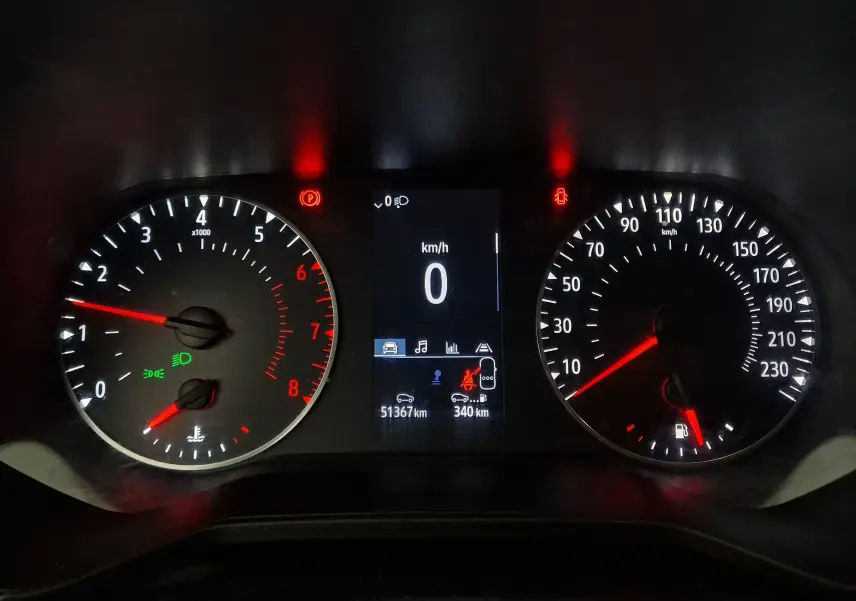 Tableau de bord éclairé de la Renault Clio V gris platine, affichant vitesse zéro et compte-tours au ralenti.