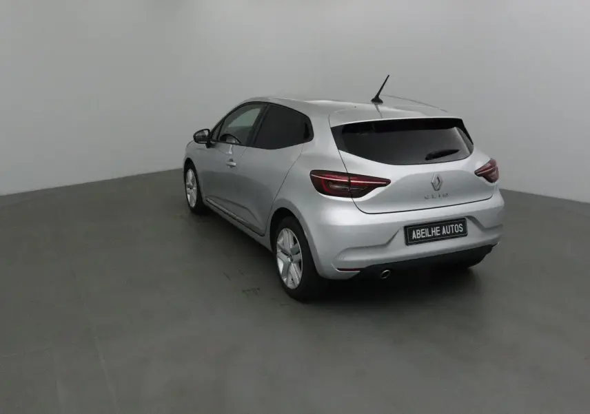 Renault Clio V gris platine vue 3/4 arrière droit dans un studio, avec vitres teintées et feux LED.