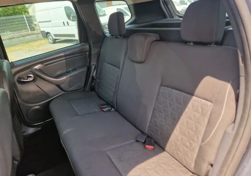 Vue intérieure de la banquette arrière du Dacia Duster gris foncé, montrant les sièges tissu avec motifs géométriques.