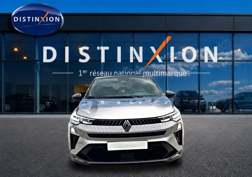 Vue avant d'un Renault Captur 2026 cassiope toit noir, avec calandre moderne et phares LED fins, devant un showroom Distinxion.