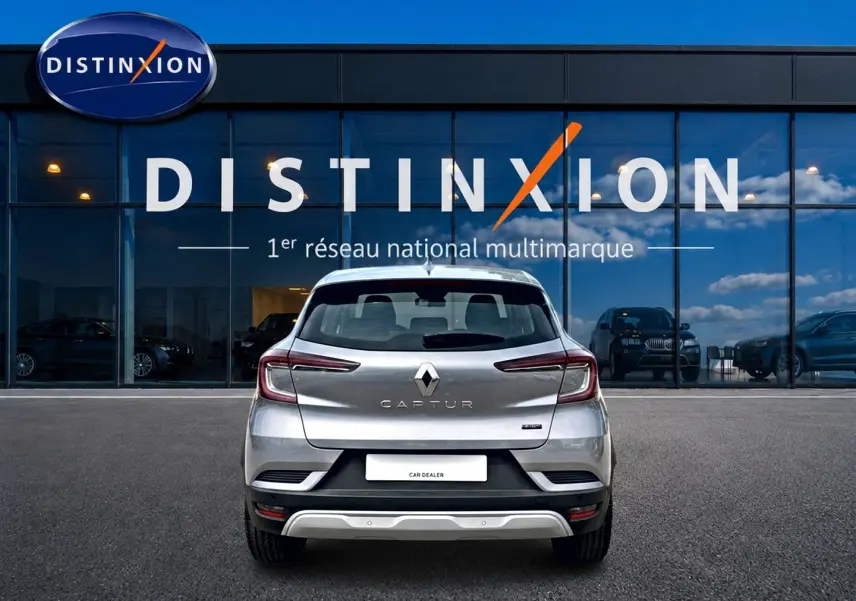 Vue arrière d'un Renault Captur 2026 gris cassiope avec toit noir, garé devant une vitrine Distinxion.