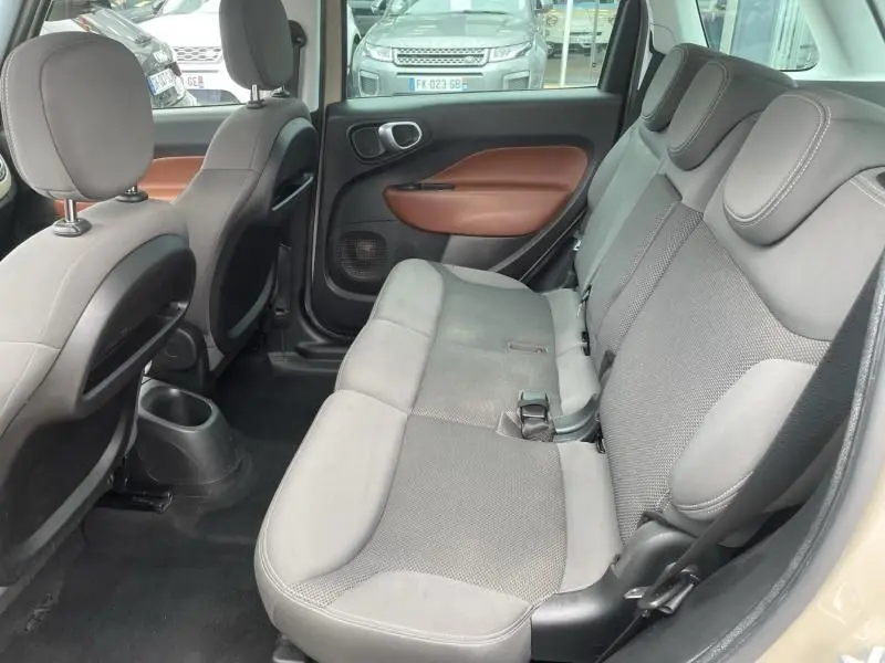 Vue intérieure côté droit de la banquette arrière grise avec garnitures marron d'une Fiat 500L beige de 2014.
