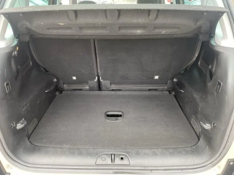 Coffre ouvert d'une FIAT 500L beige 2014, vue intérieure arrière montrant l'espace de chargement et la banquette rabattue.