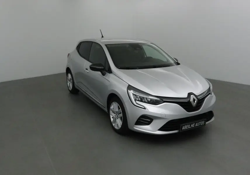 Renault Clio V gris platine vue 3/4 avant droit, avec phares LED et calandre noire distinctive.