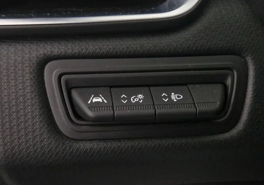Boutons de réglage d'assistance à la conduite et éclairage sur tableau de bord noir d'une Renault Clio V gris platine.