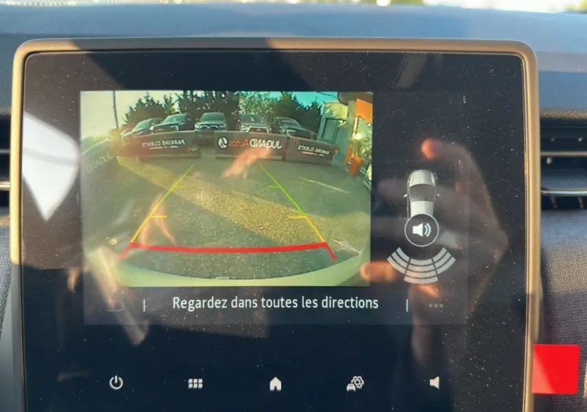 Écran de caméra de recul de la Renault Clio DCI 100 Evolution Gris Rafale montrant l'arrière avec lignes de guidage colorées.