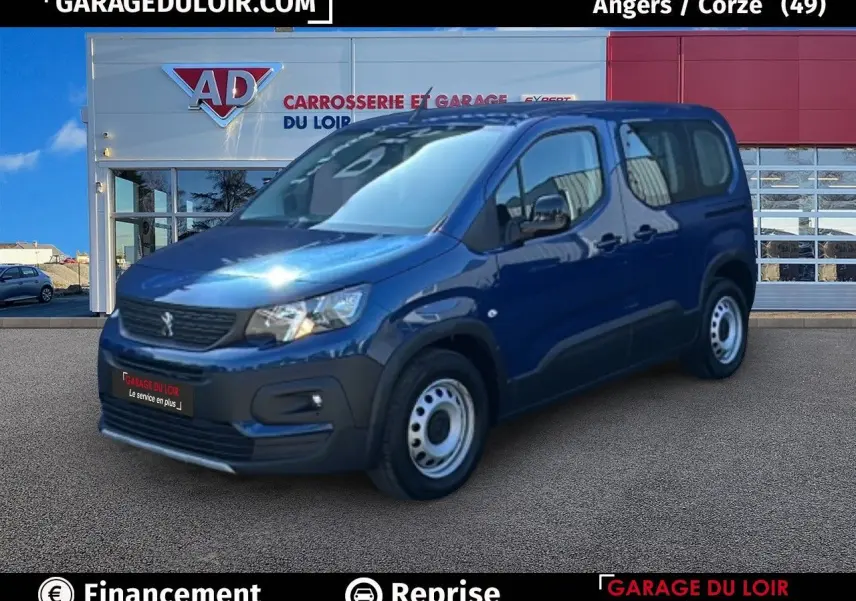 Peugeot Rifter bleu en 3/4 avant droit, avec jantes tôles et porte latérale coulissante visible.
