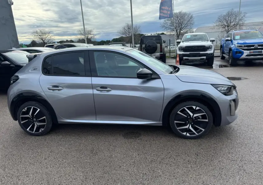 Profil droit d'une Peugeot 208 Hybrid 110 GT gris avec jantes alliage 17 pouces et vitres teintées.