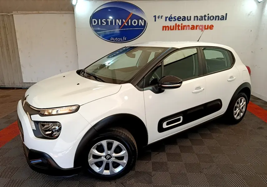 Citroën C3 blanche vue 3/4 avant droit avec protections latérales noires et jantes alliage.