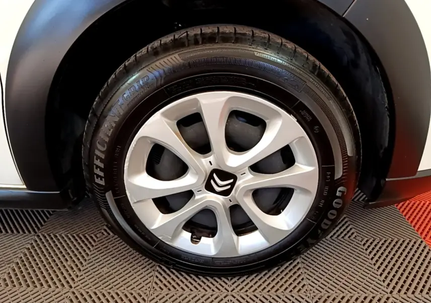Gros plan sur la roue avant droite blanche d'une Citroën C3 2022 avec jante alliage et logo Citroën central.