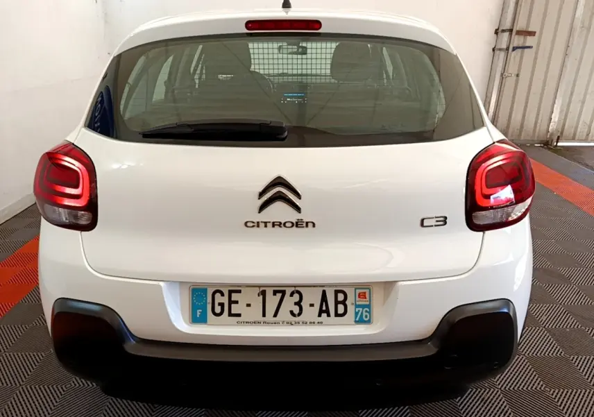 Vue arrière d'une Citroën C3 blanche 2022 avec feux arrière LED et pare-chocs noir dans un garage.