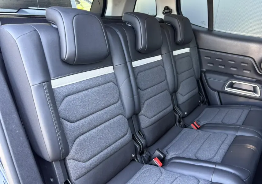 Vue intérieure des trois sièges arrière indépendants en tissu et cuir noir du Citroën C5 Aircross Hybrid 2025.