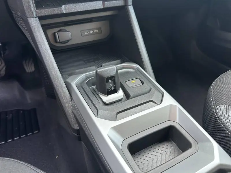 Gros plan sur la console centrale du Dacia Duster 2025 hybride, montrant le levier de vitesses automatique et le bouton de stationnement.