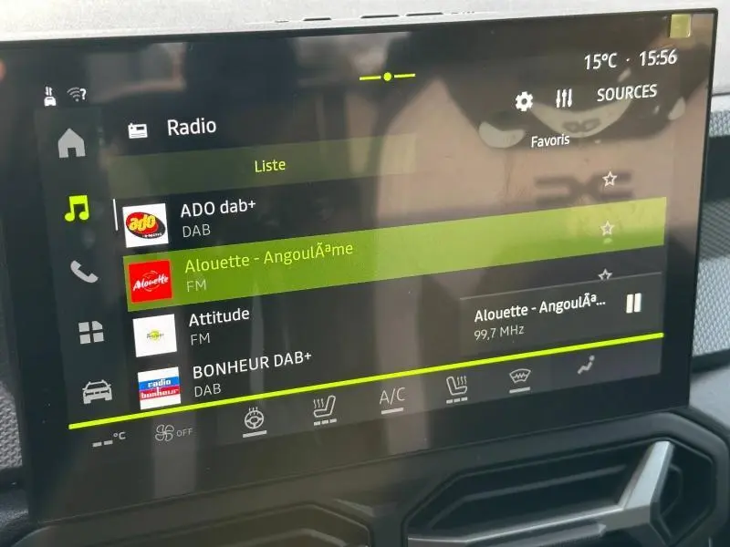 Écran tactile central du tableau de bord du Dacia Duster 2025 affichant les stations radio, avec interface moderne et détails en vert.