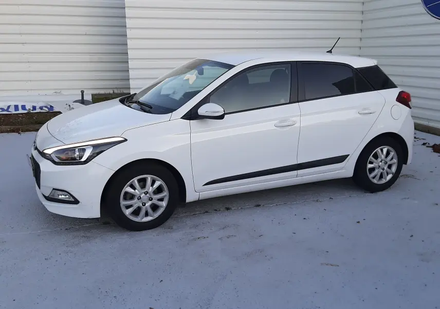 Hyundai i20 blanc vue de profil côté gauche, compacte 5 portes avec jantes alliage et vitres teintées.
