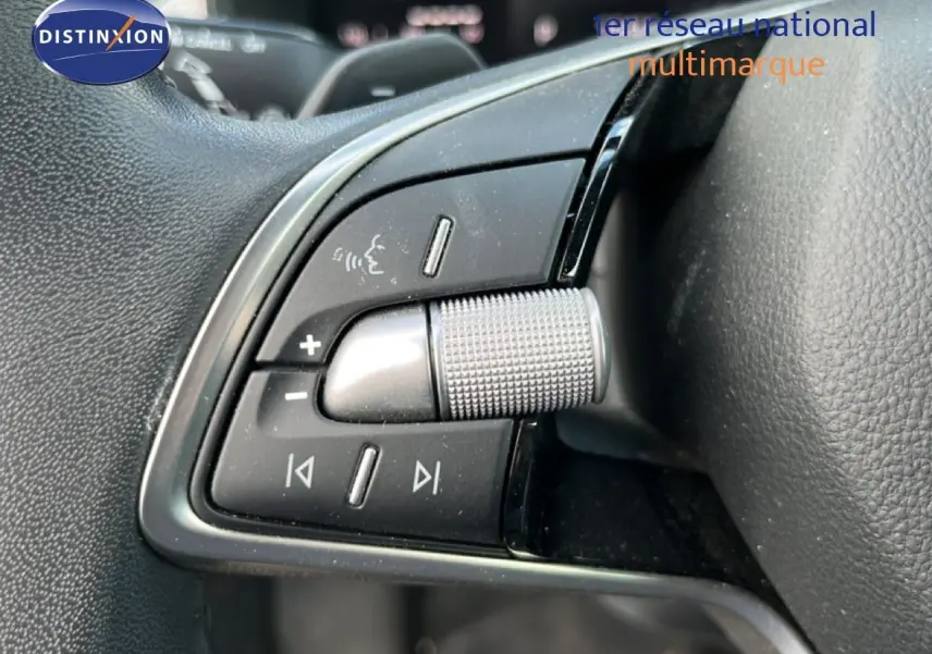 Gros plan sur les commandes de volume et audio au volant d’une Skoda Scala 2025, finition gris noir.