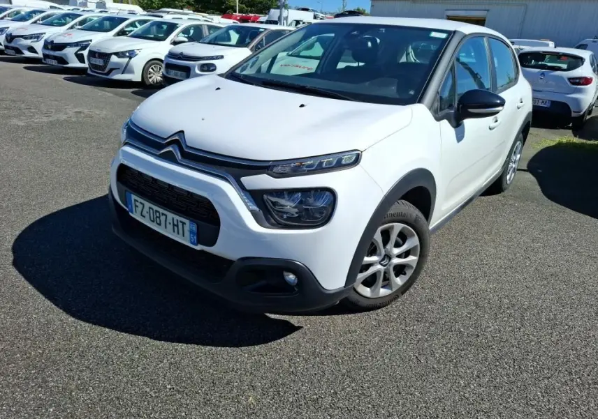 Citroën C3 Société blanche vue en 3/4 avant droit, avec calandre noire et protections de bas de caisse noires.