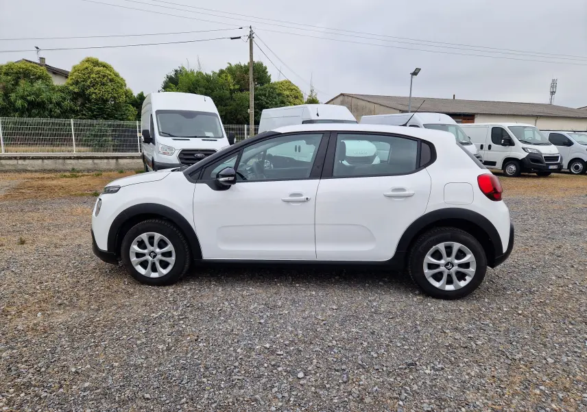 Vue de profil côté gauche d'une Citroën C3 Société blanche 2021 avec protections noires sur les passages de roues.