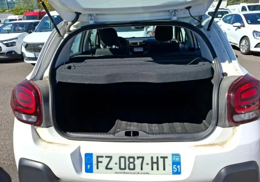 Vue 3/4 arrière droite d'une Citroën C3 Société blanche avec feux arrière distinctifs et pare-chocs noir.