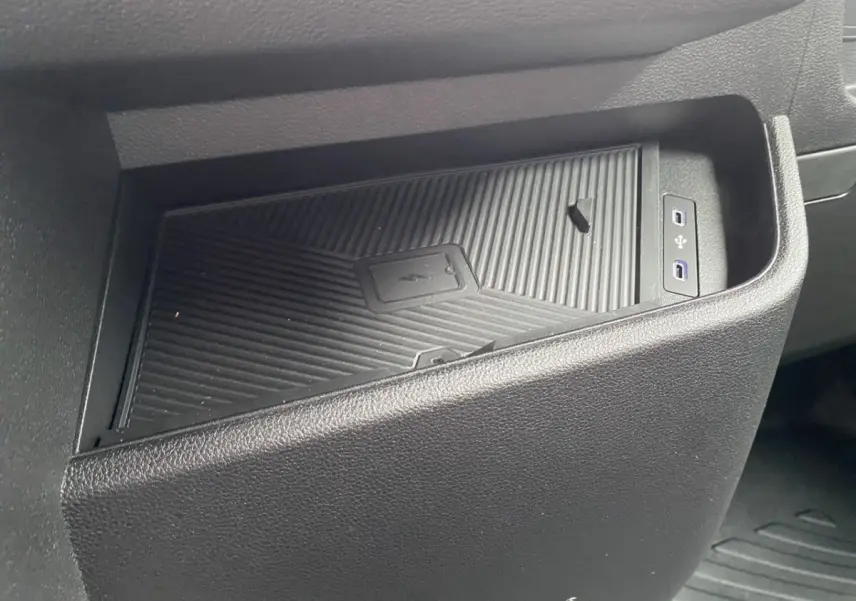 Gros plan sur la zone de recharge par induction et ports USB avant du Renault Master 2026, intérieur noir.