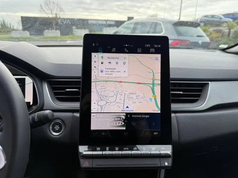Vue intérieure du tableau de bord du Renault Captur 2025, écran tactile central affichant une carte de navigation.