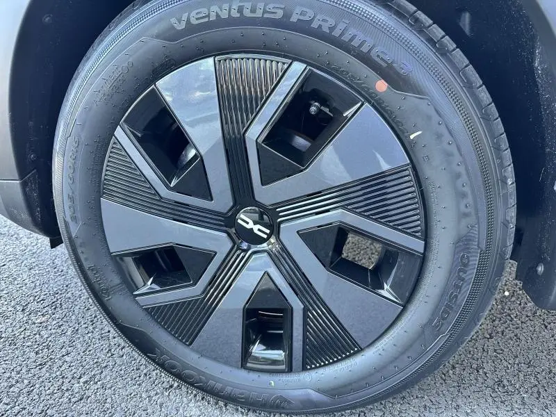 Gros plan sur la roue avant droite du Dacia Sandero beige Safari, mettant en valeur la jante noire au design moderne.