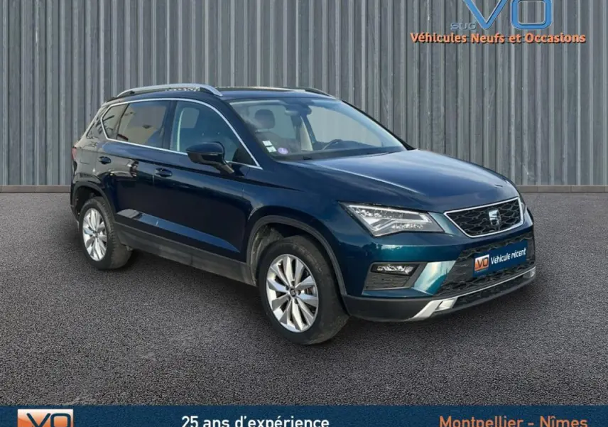SEAT Ateca bleu foncé en 3/4 avant droit, avec jantes alliage 17 pouces et calandre chromée visible.