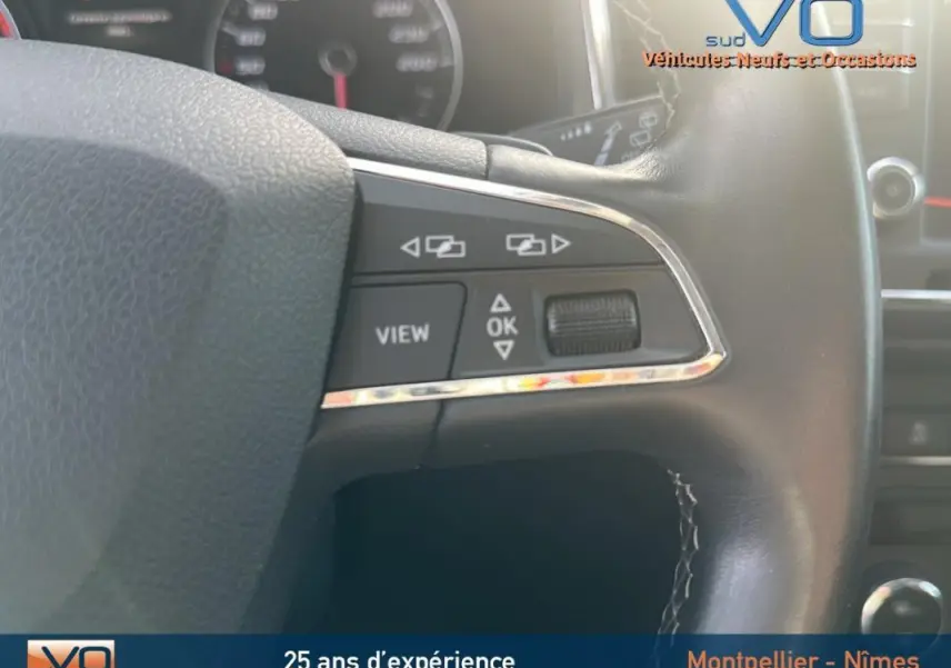 Gros plan sur le volant multifonctions en cuir de la SEAT Ateca bleu foncé, montrant les commandes de navigation et de vue.