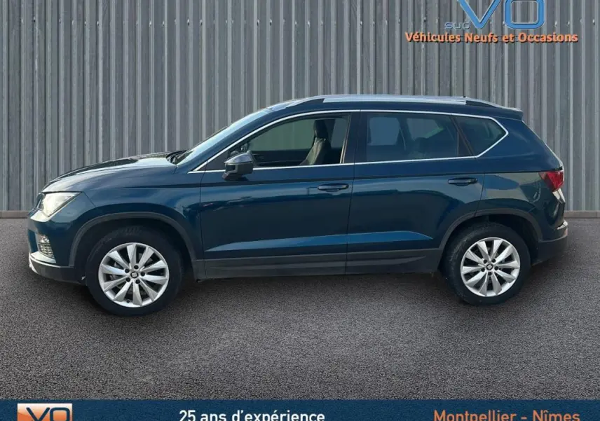 Profil latéral droit d'un SEAT Ateca bleu foncé 2019 avec jantes alliage 17 pouces et vitres teintées.