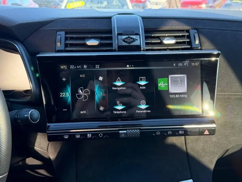 Vue rapprochée du tableau de bord du DS7 E-TENSE 225ch 2024, avec écran tactile et commandes climatisation visibles.
