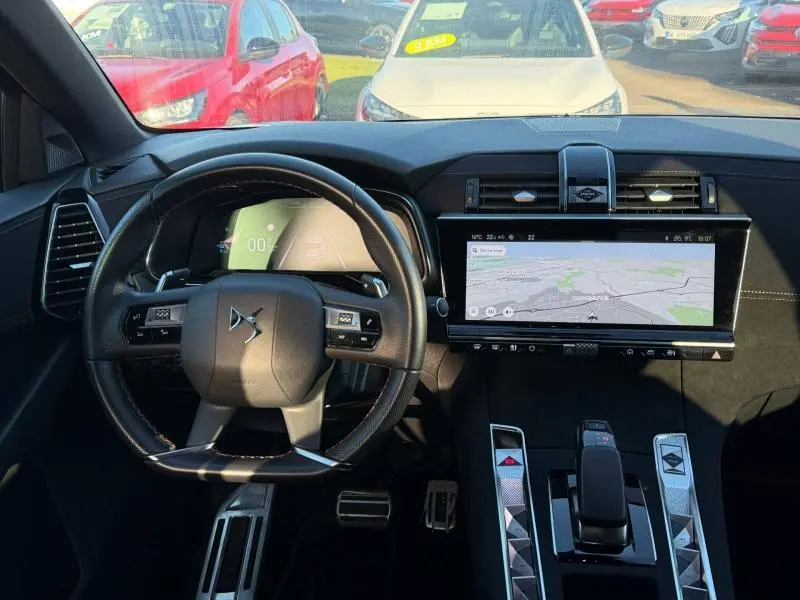Intérieur du DS7 E-TENSE 225ch 2024 montrant le tableau de bord et volant noir avec écran tactile central large.