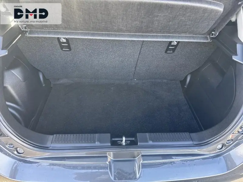 Coffre ouvert vu de l'arrière d'une Suzuki Swift 1.2 Hybrid 83ch Privilège en Mineral Gray Metal, espace de chargement vide.